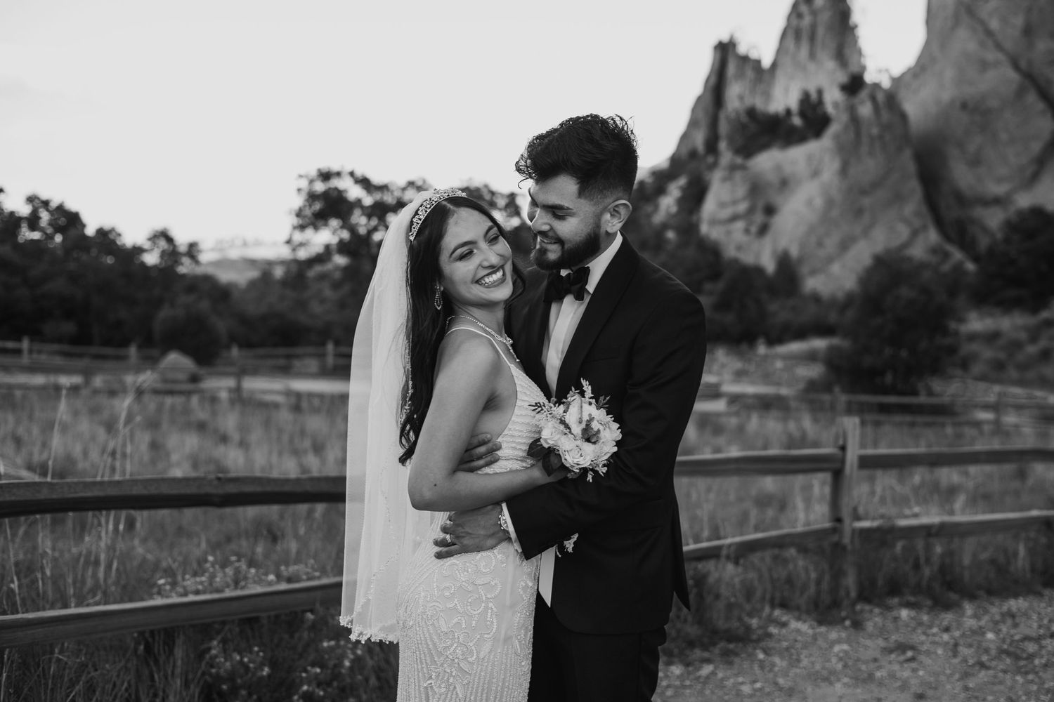 Bride and groom embracing outdoors at Garden of the Gods in black and white wedding portrait.