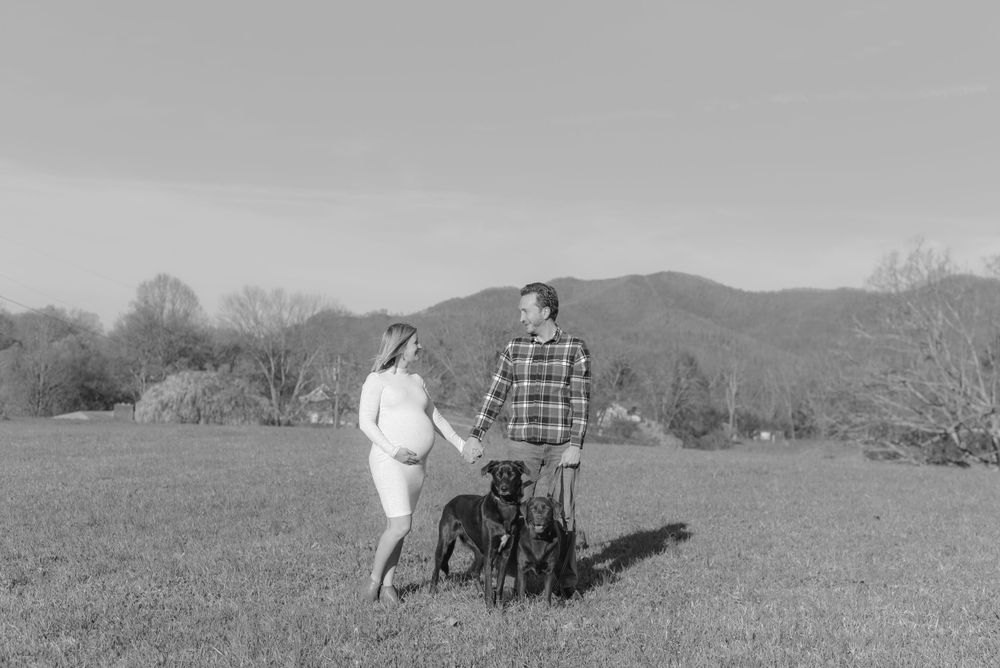A couple takes artistic black and white photos in a scenic mountain landscape.