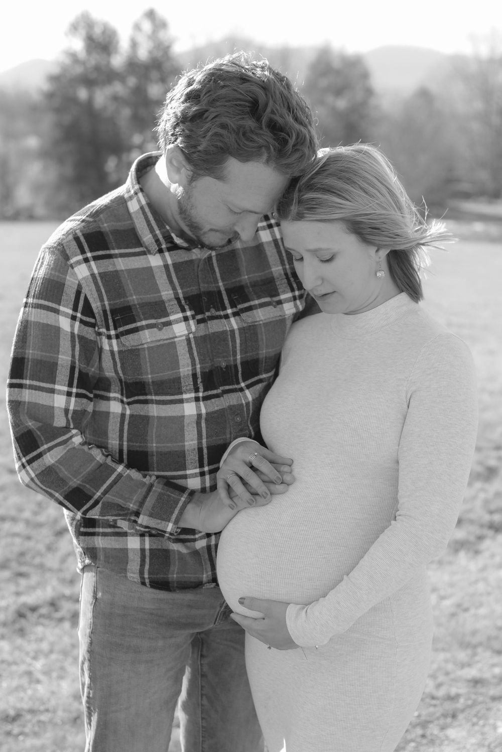 A romantic couple shares intimate moments in a series of black and white photos outdoors.