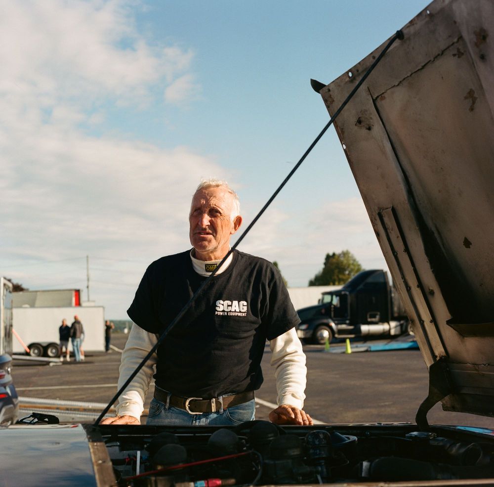 A portrait of Derek Drinkwater and his classic Cadillac Lemans car. Taken at Watkins Glen.