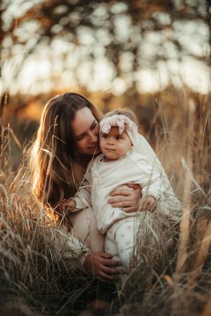 Mamma myser med sin dotter på en äng