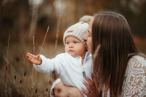 Mamma med sin bebis en höst dag