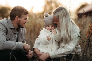 Familj på en äng i höstmiljö