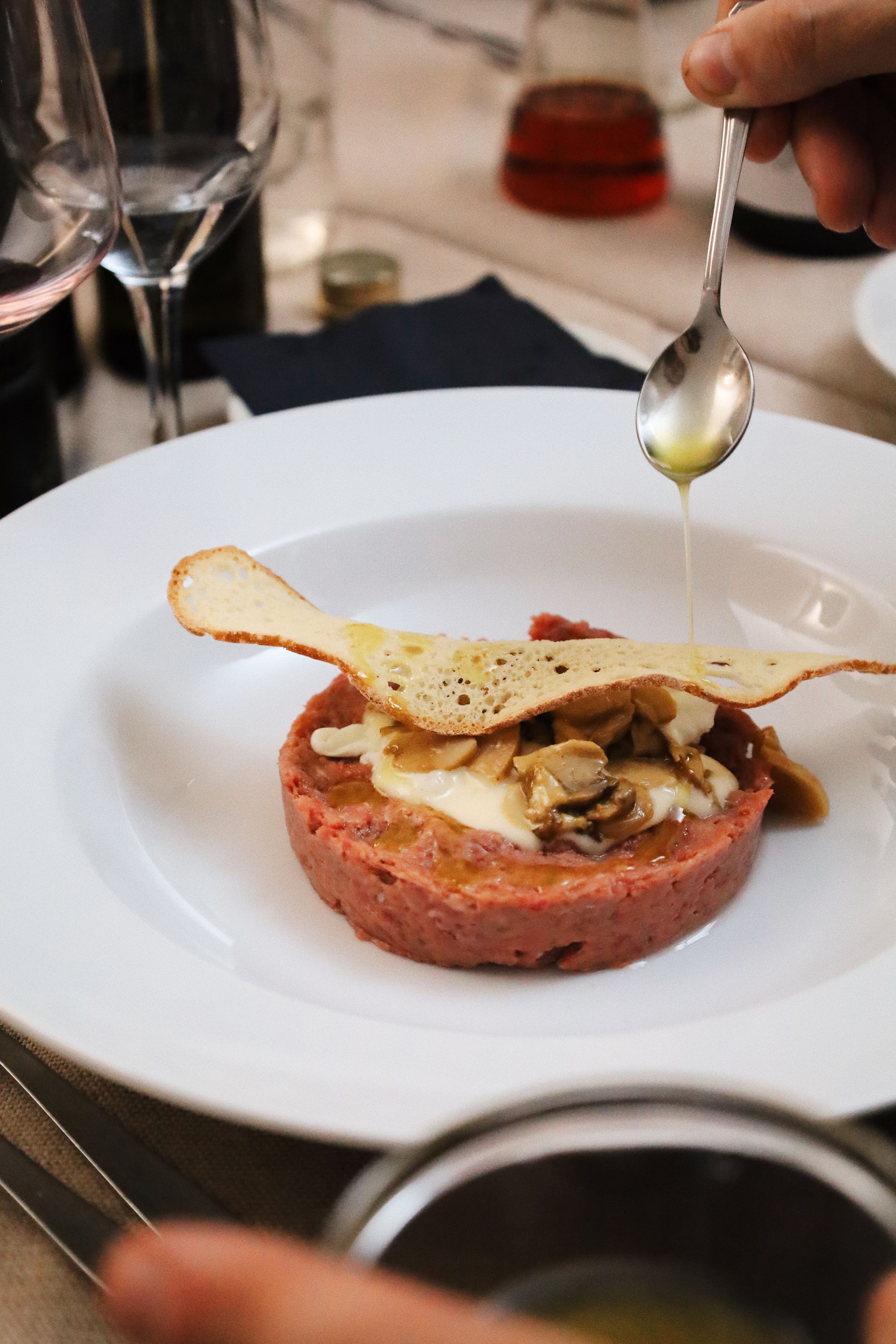 Elegant plating of a mushroom tart with delicate garnishes on white dinnerware.