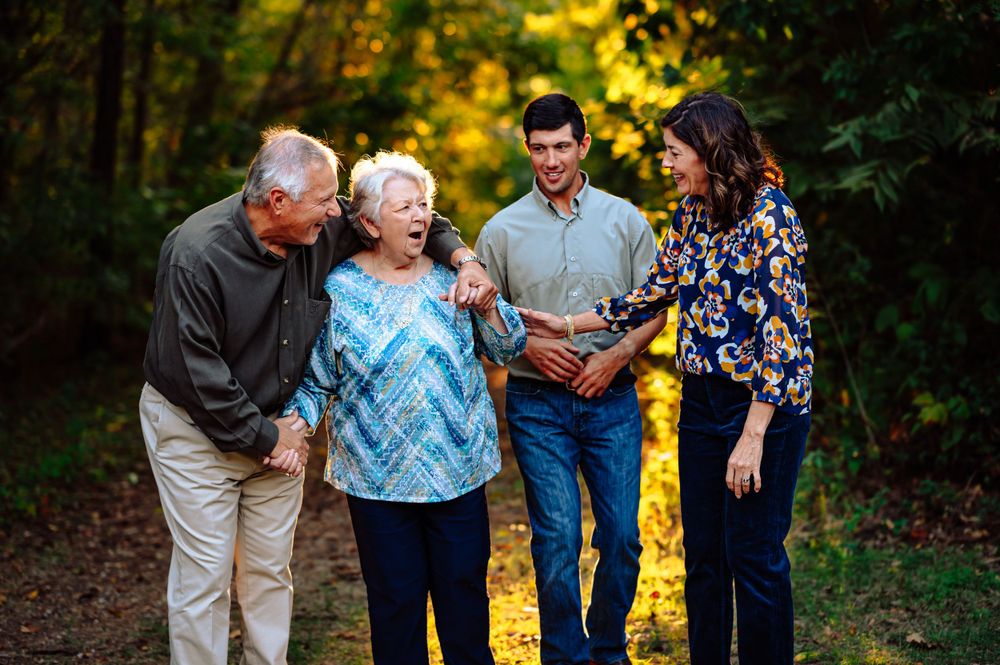 family of 3 poses with grandma during dallas area extended family photo session outdoors at sunset
