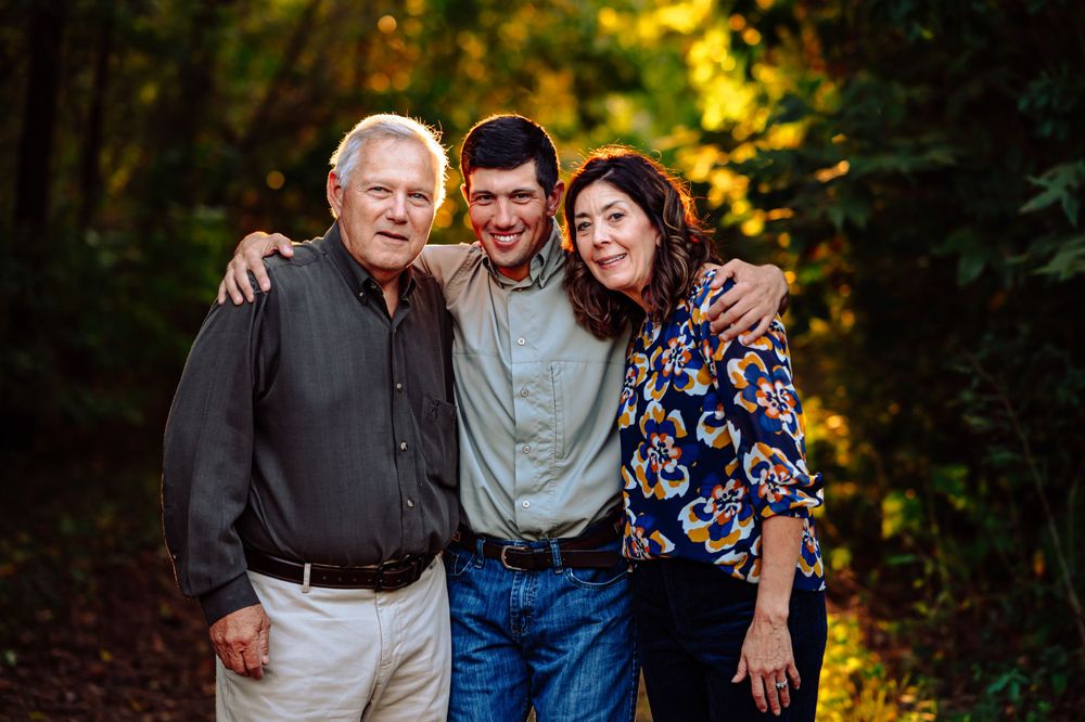 Couple poses with adult son for dallas area sunset outdoor extended fall family photo session
