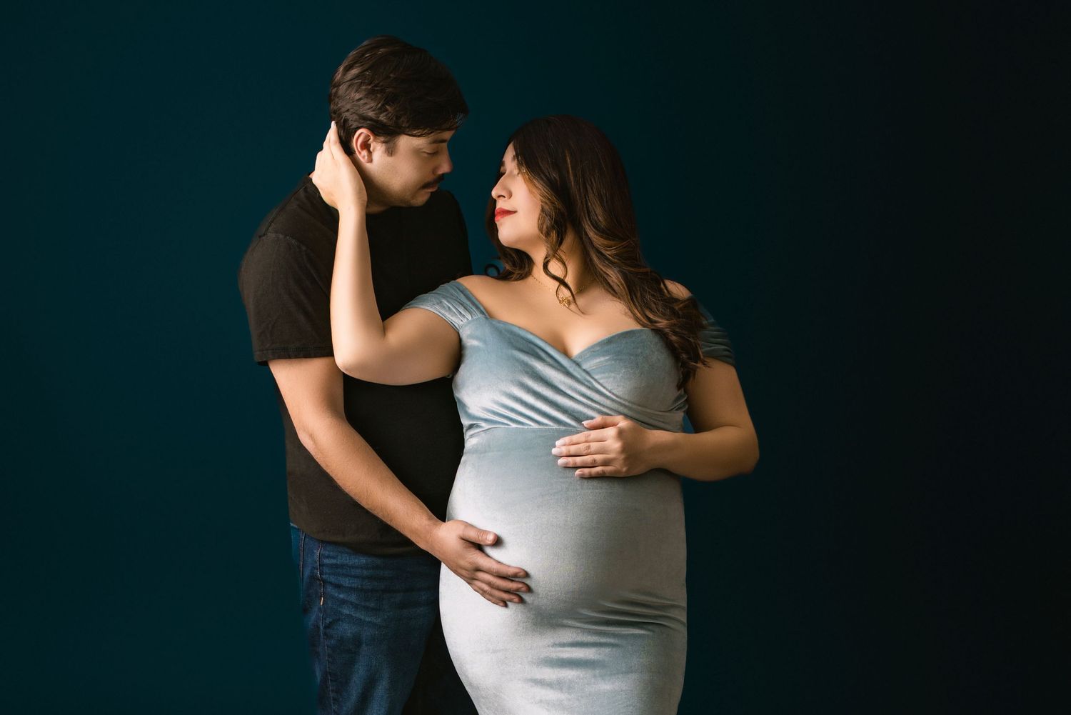 An expectant couple showcases their love during a photo shoot at a photography studio specializing in pregnancy  photos.