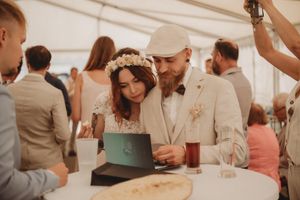 Couple sharing an intimate moment at a wedding reception under white tent.