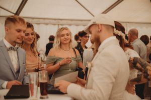 Guests enjoying drinks and conversation at casual outdoor wedding reception.