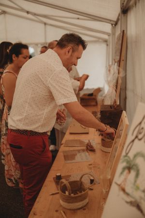 Guest serving themselves food at wooden buffet table during event.