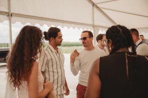 Small group engaged in animated conversation at outdoor summer event.
