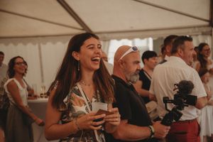 Party guests enjoying themselves at an indoor event under a white tent.