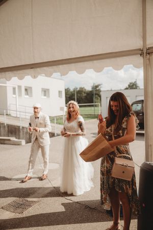 Wedding guests gathering outside a white tent during a celebration.