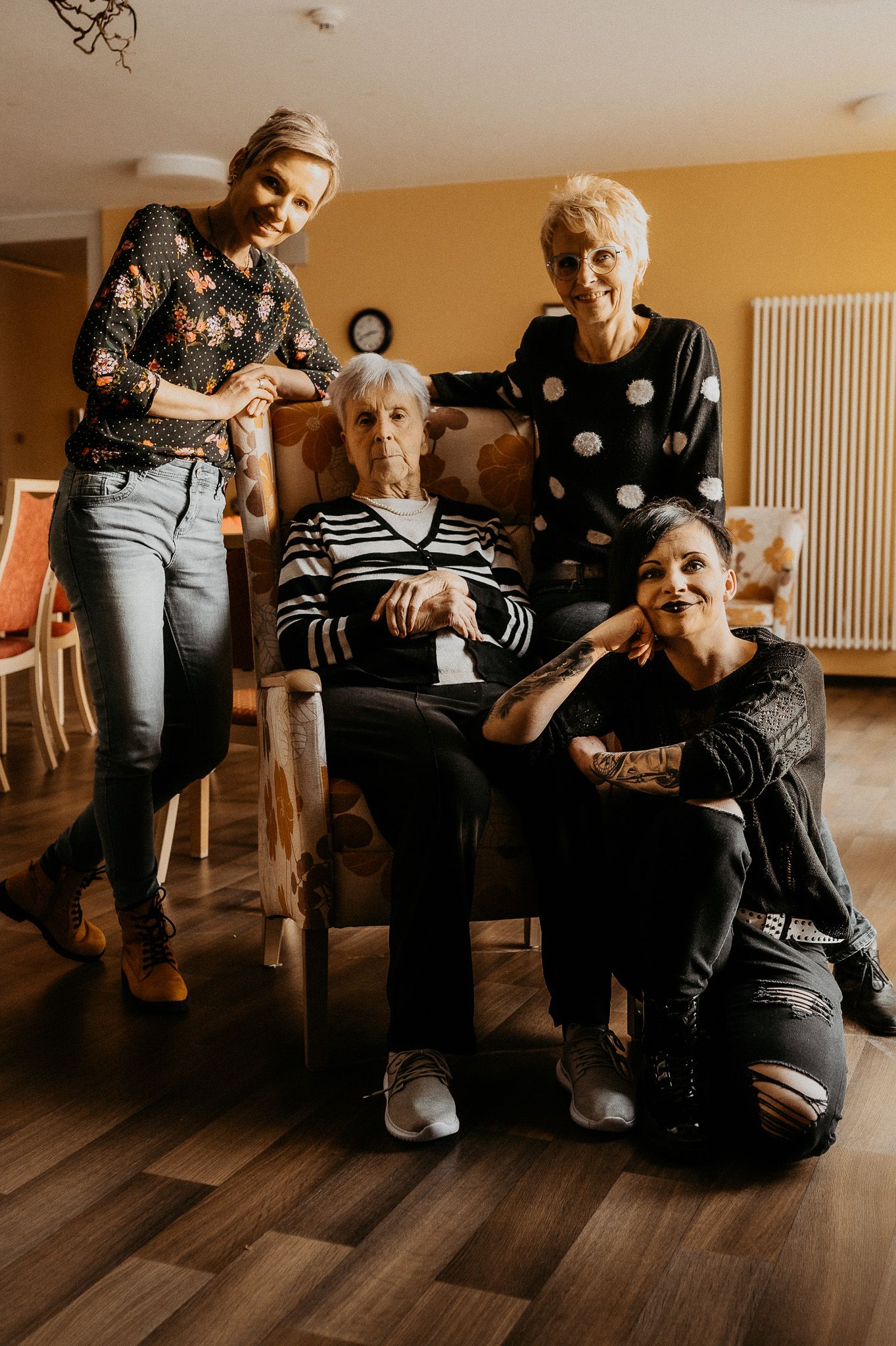 A multigenerational family gathering in a warmly lit living room.