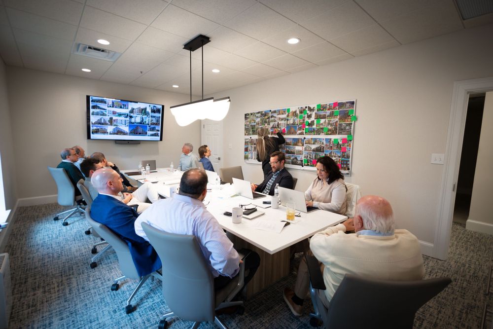 Corporate team meeting in modern conference room with displays and presentation materials.