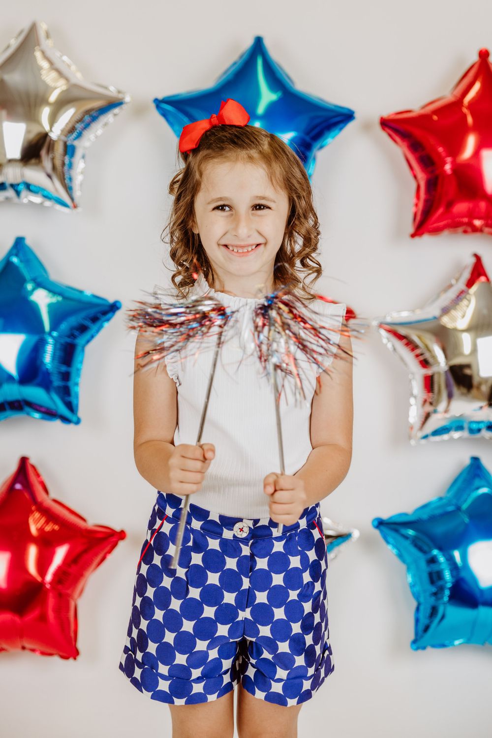 Holiday photo with sparklers and metallic star balloons against white background.