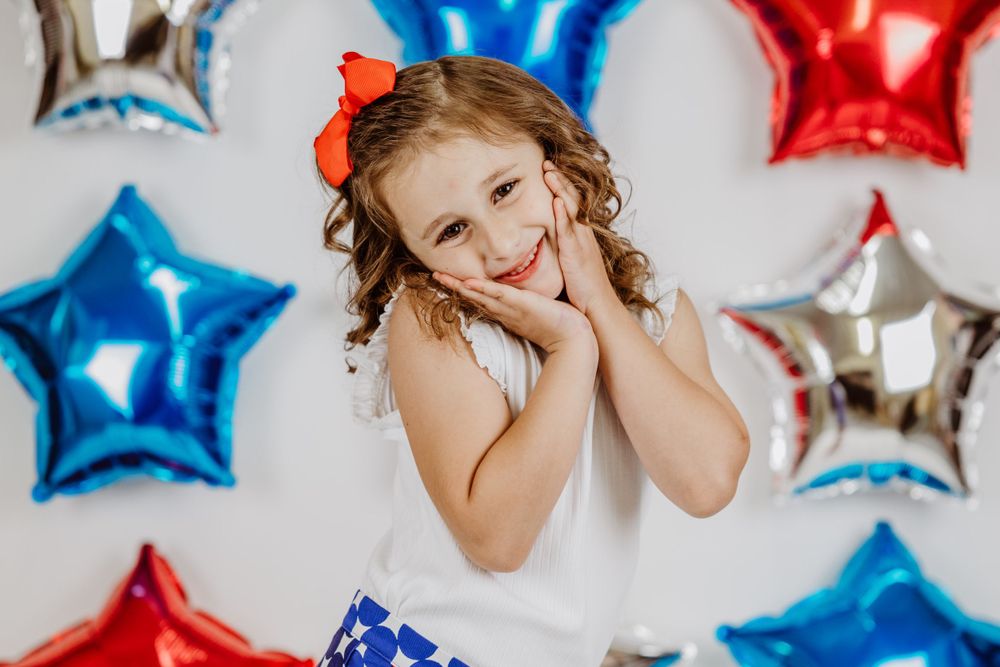 Sweet patriotic portrait with star balloons and festive decorations.