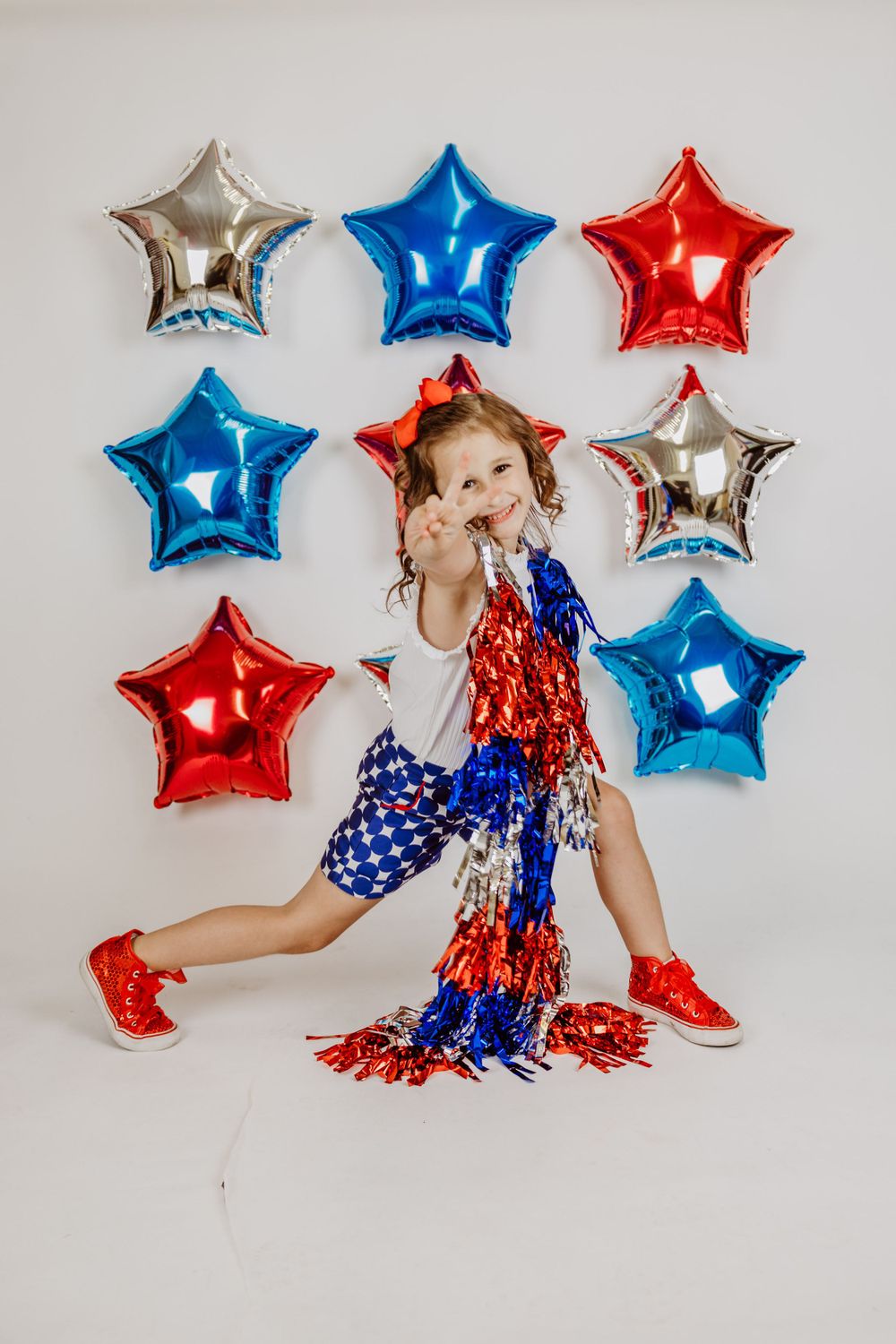 Dynamic pose with patriotic tinsel garland against star balloon background.