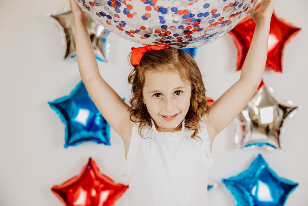 Patriotic themed party setup featuring star-shaped foil balloons in American flag colors.