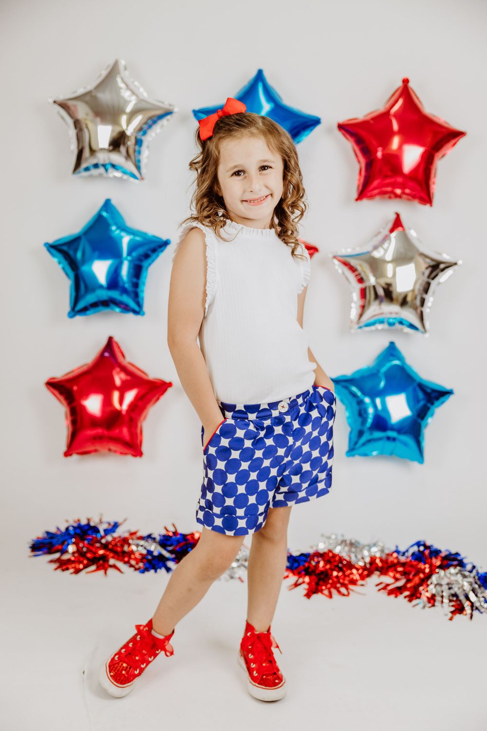 Fourth of July themed scene with star-shaped balloons and patriotic outfit details.
