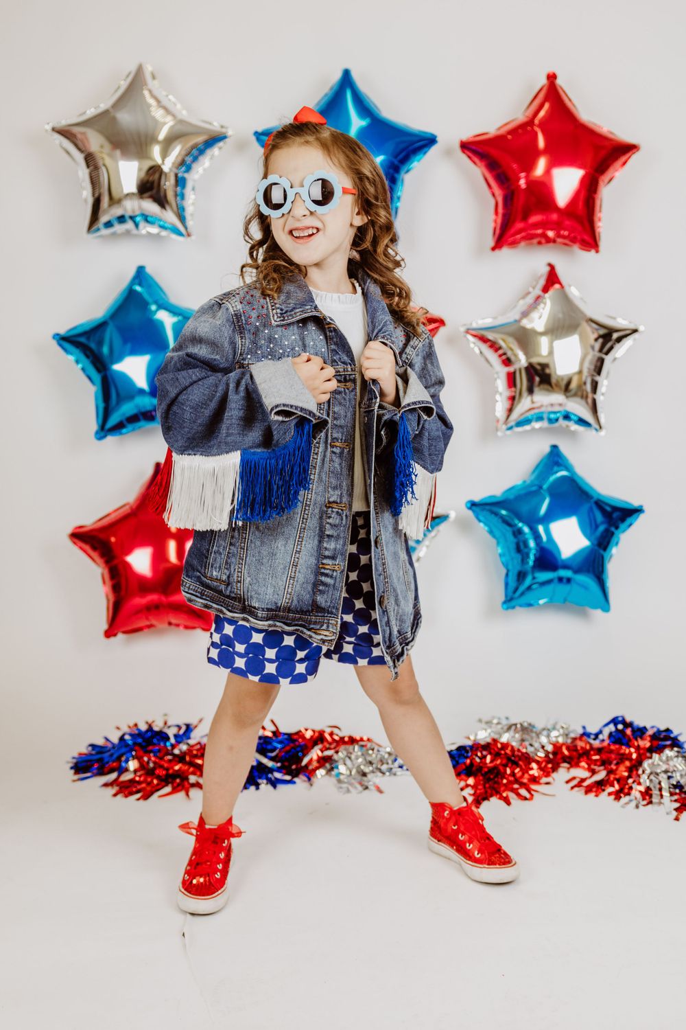 Patriotic photo session with denim jacket, star balloons and red white and blue decor.