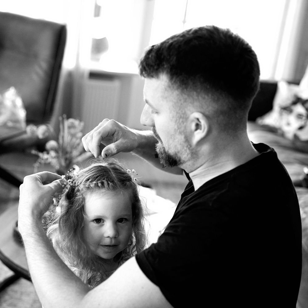 Black and white photo capturing an intimate hair styling moment.
