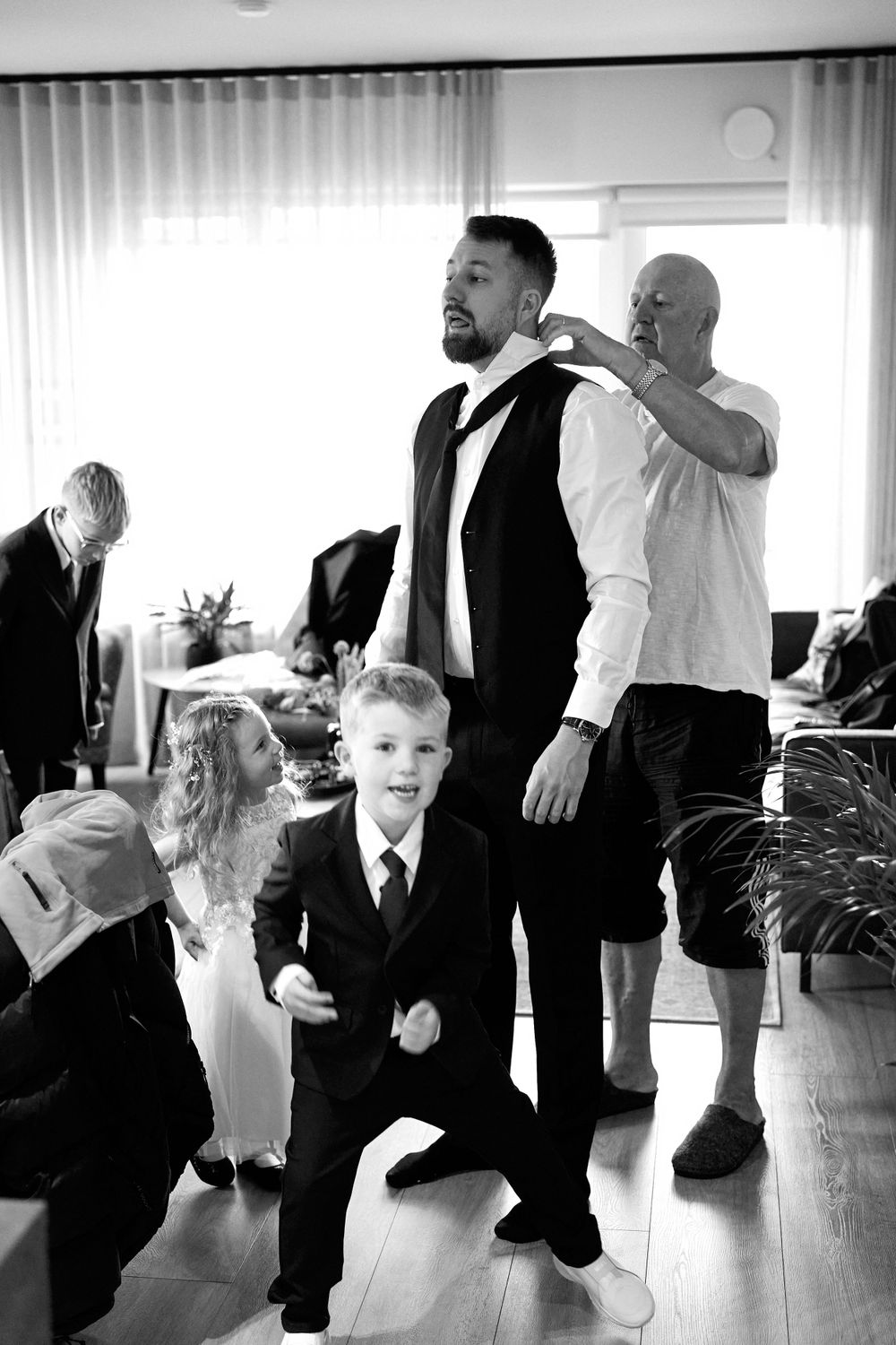 Black and white candid shot of wedding preparations with formal attire.