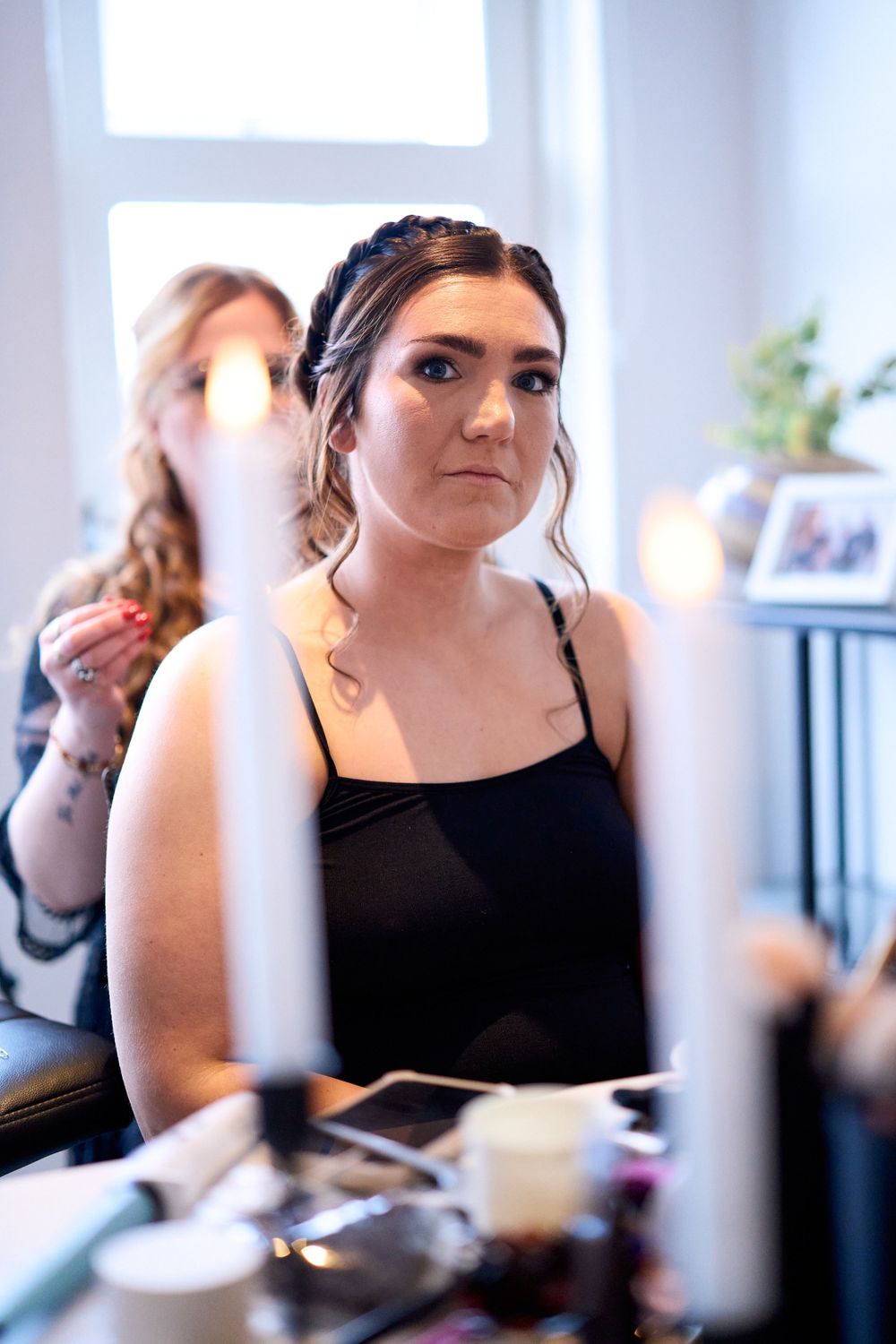 Elegant pre-wedding makeup preparation with soft window lighting.