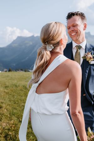 A wedding portrait with mountain backdrop featuring a modern minimalist bridal look.
