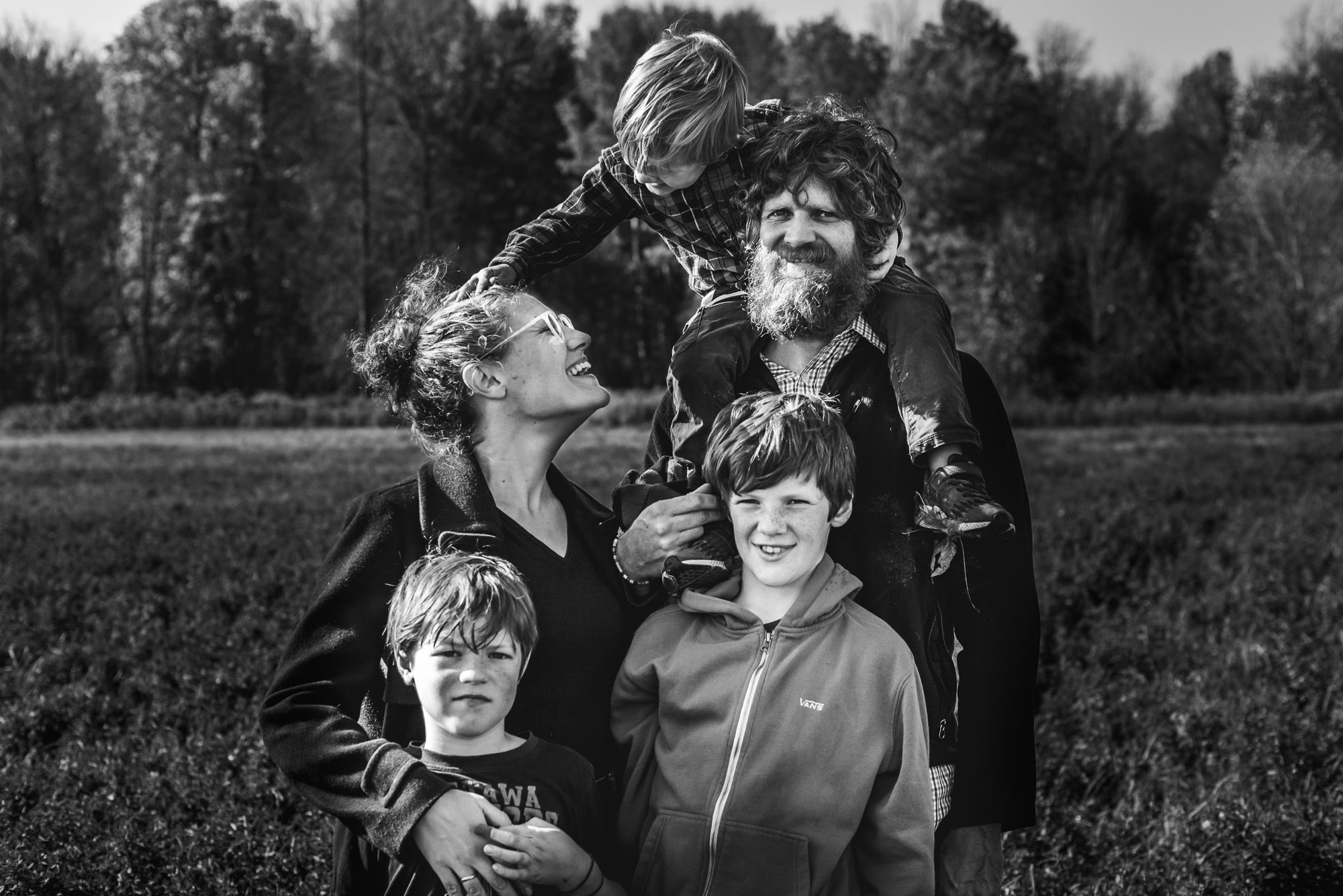 BW family photograph with 3 kids and parents.