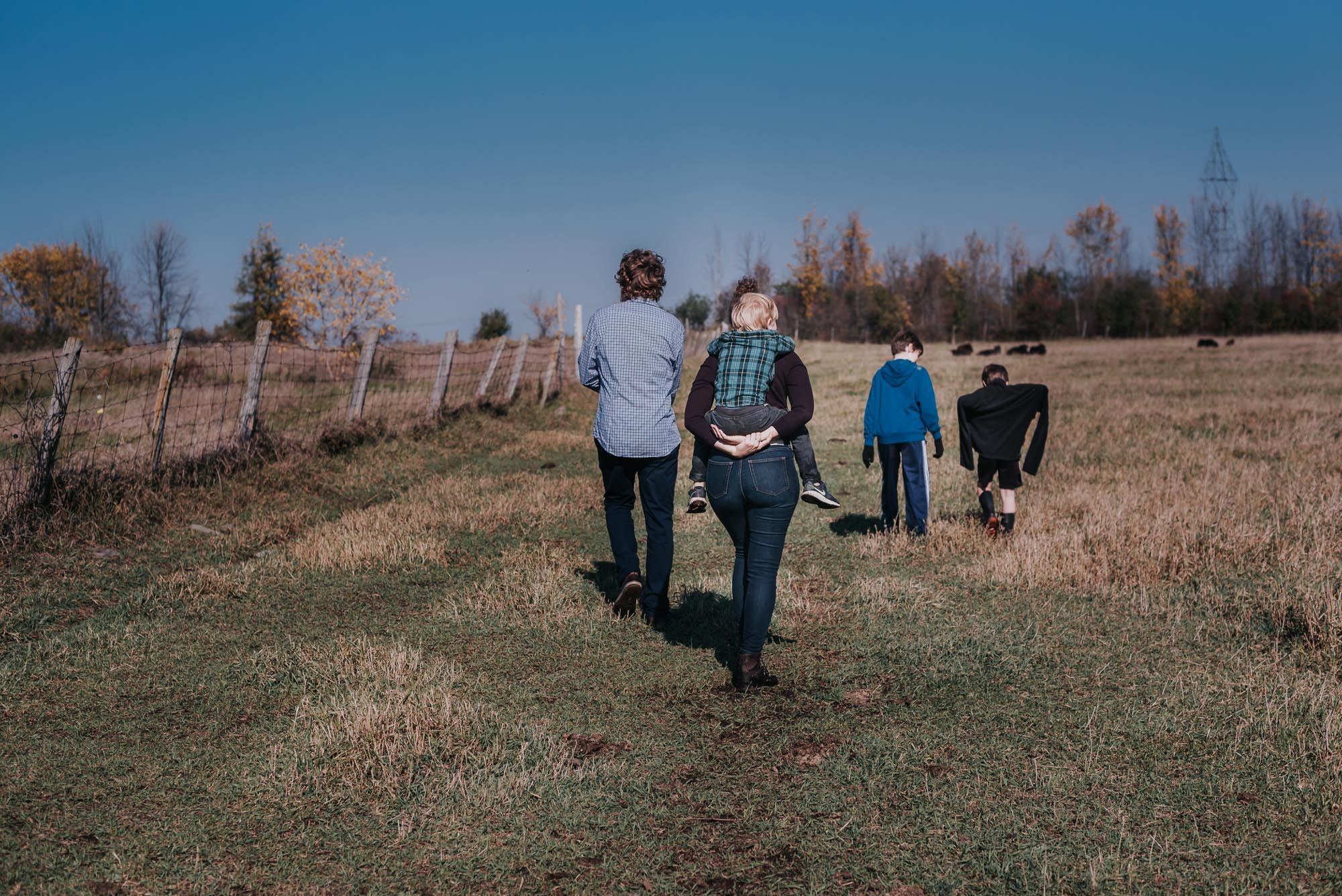 A family walks away towards their farm.