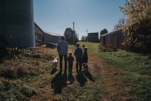 A family walks toward the sun light at their farm.