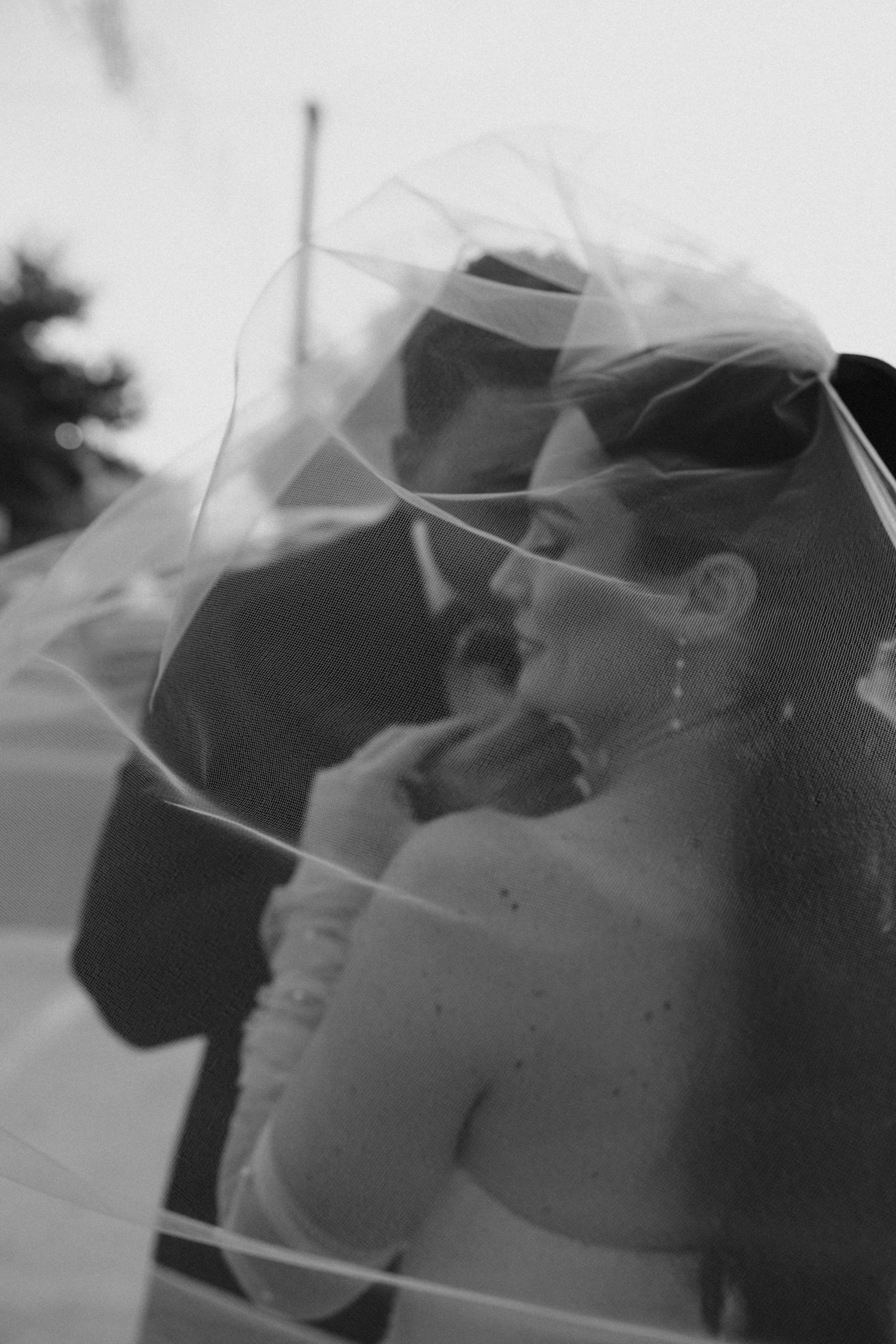 Black and white bridal portrait featuring a bride in a classic wedding gown holding a bouquet.