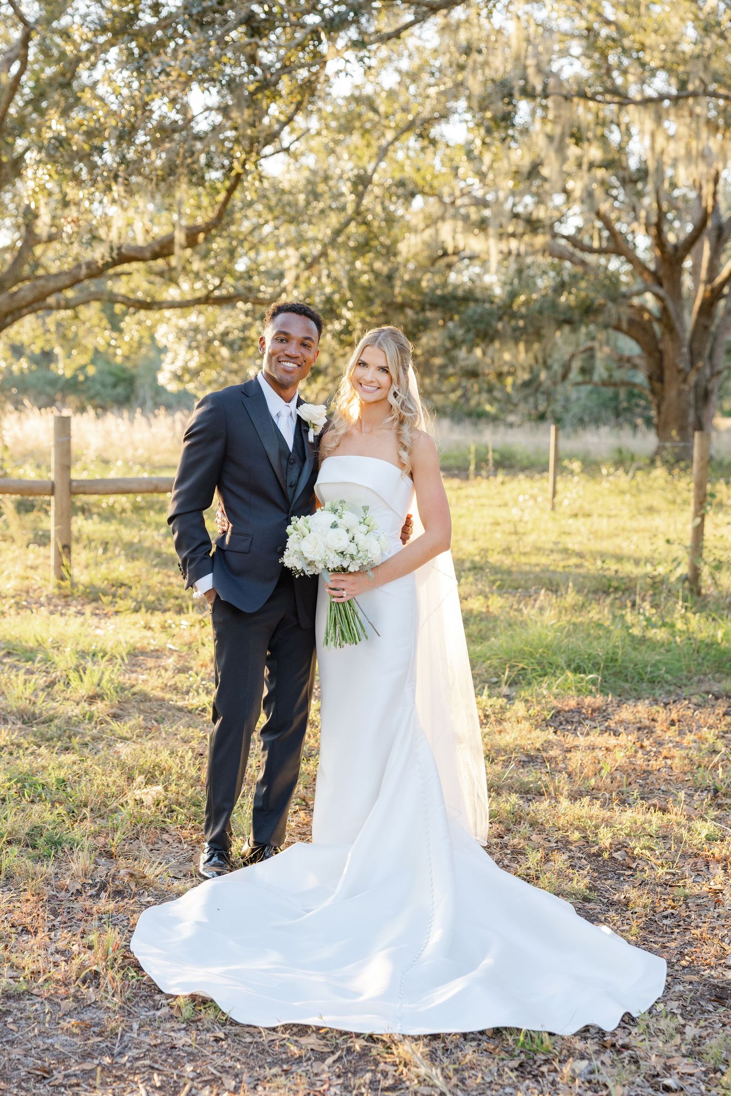 Romantic wedding portrait of a bride and groom embracing during golden hour outdoors.