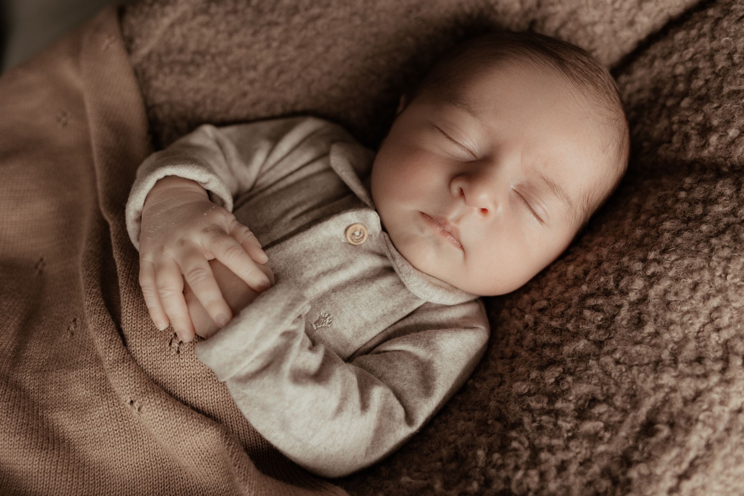 Foto van slapende baby tijdens newbornshoot aan huis