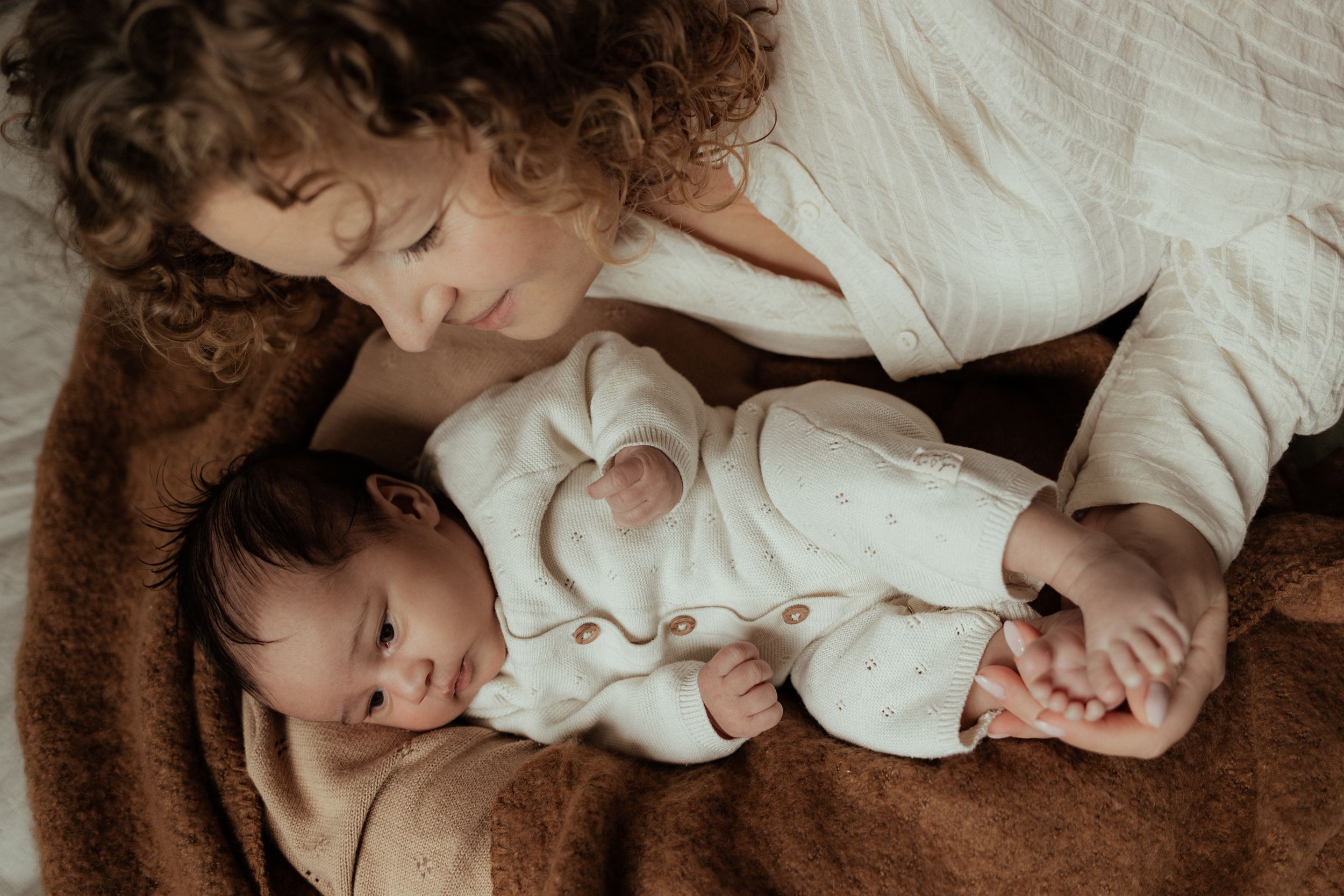 Foto van een mama met haar baby tijdens newbornshoot aan huis