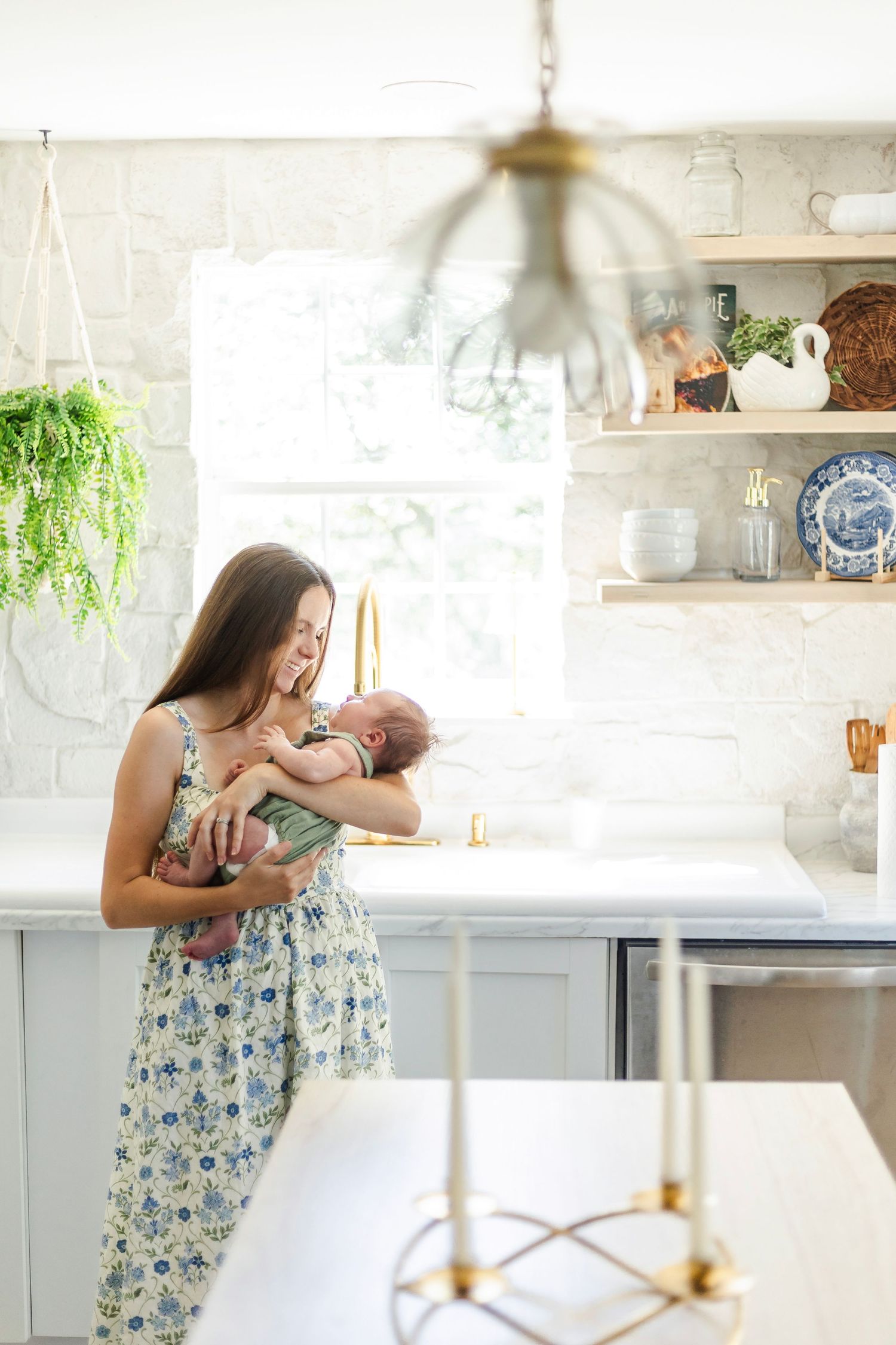 A bright a cozy photo of a mom and baby in a kitchen.