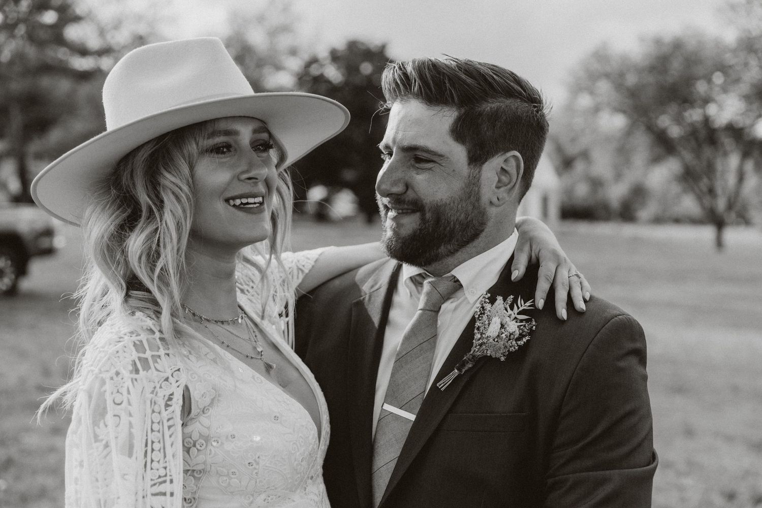 A romantic black and white portrait of a couple on their wedding day, wearing a lace gown and dark suit outdoors in hunterdon county nj.