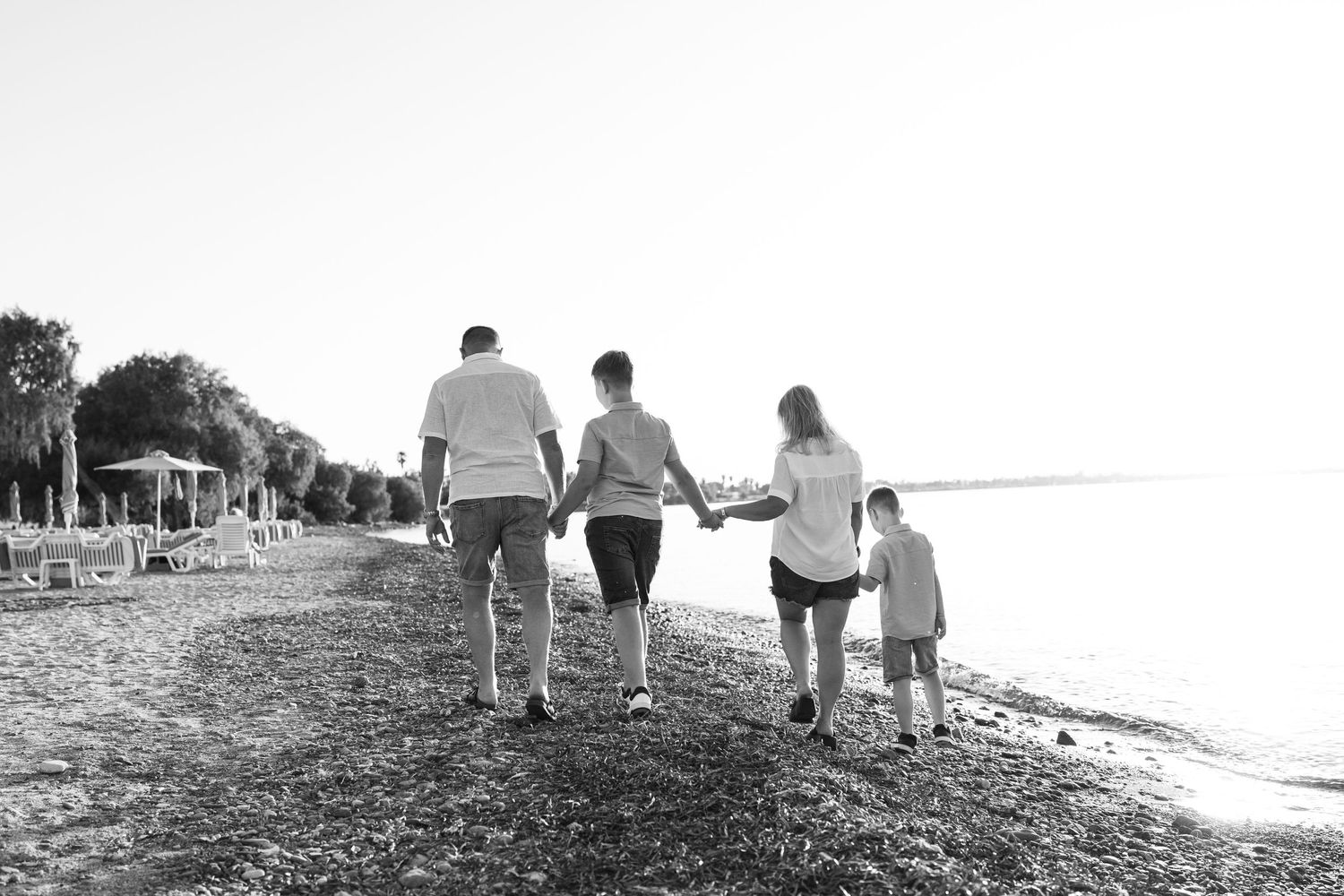 Family of four photography beach walk holding hands