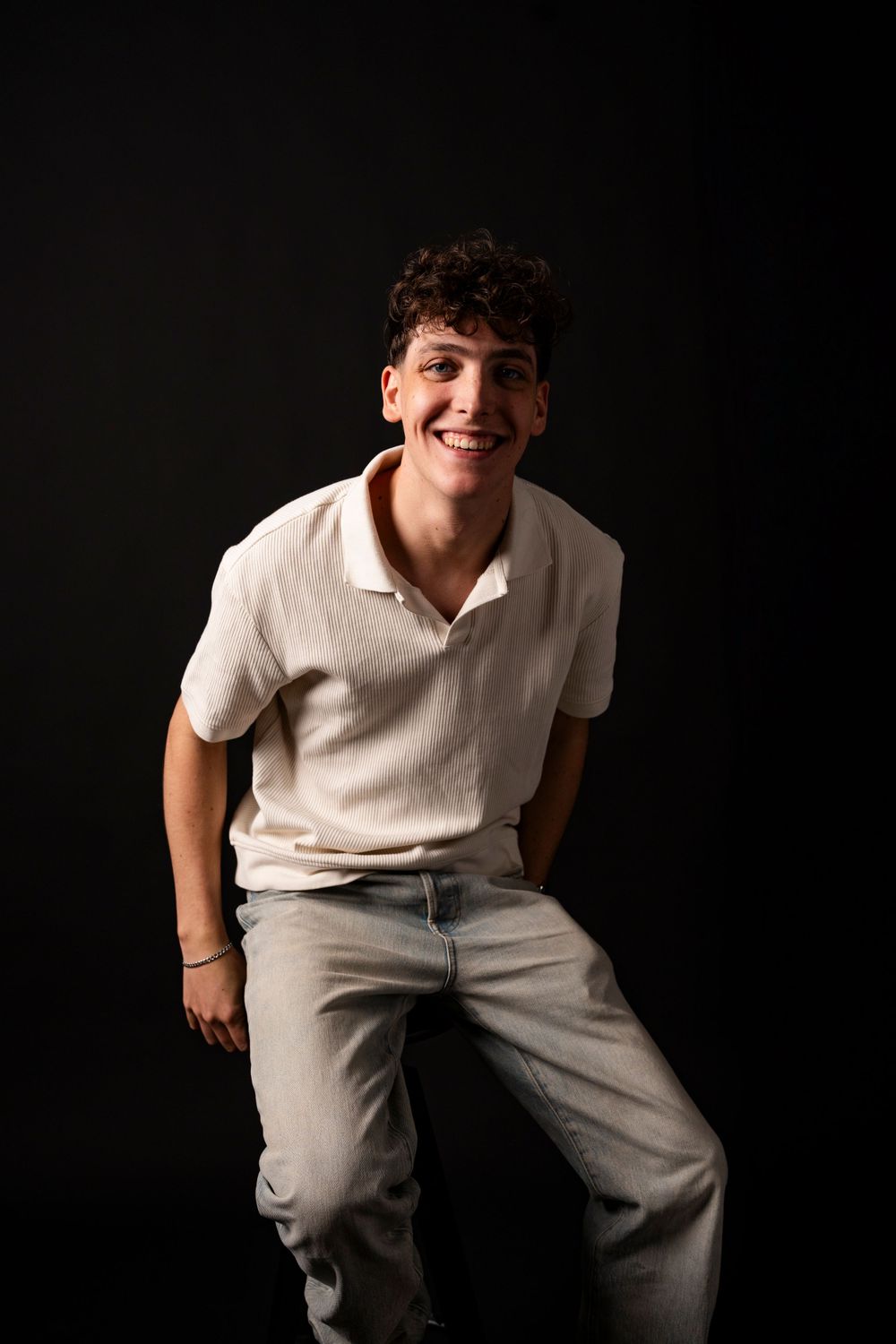 Studio portraits featuring someone in a white polo shirt against a dark background.