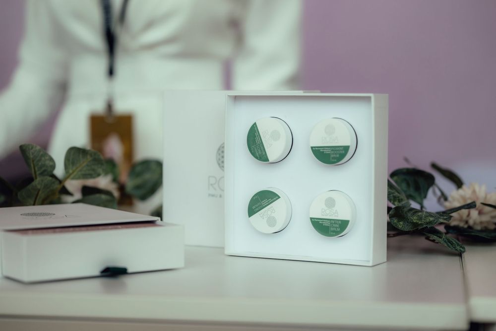 Minimalist white display featuring geometric mirror or metal pieces in circular patterns.