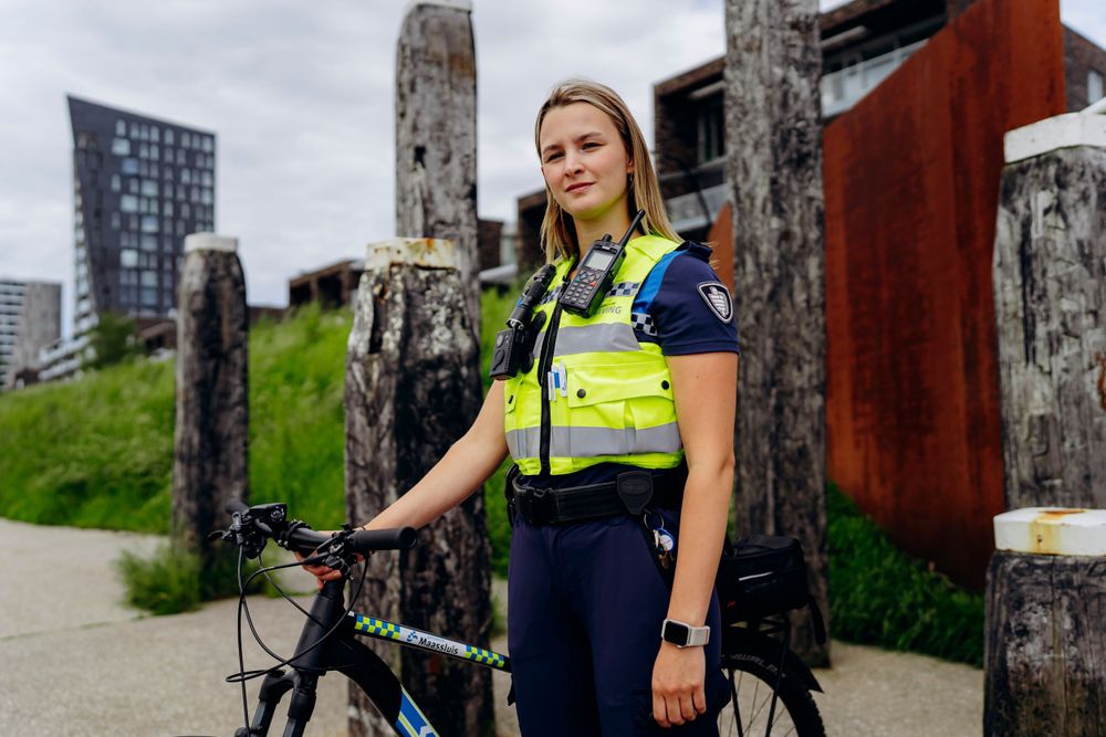 Law enforcement officers in high-visibility vests patrolling near urban architecture.