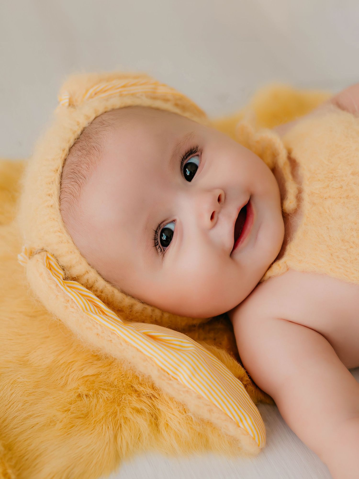 Niña de seis meses vestida de conejita en tonos amarillos en una sesión fotográfica de seguimiento.