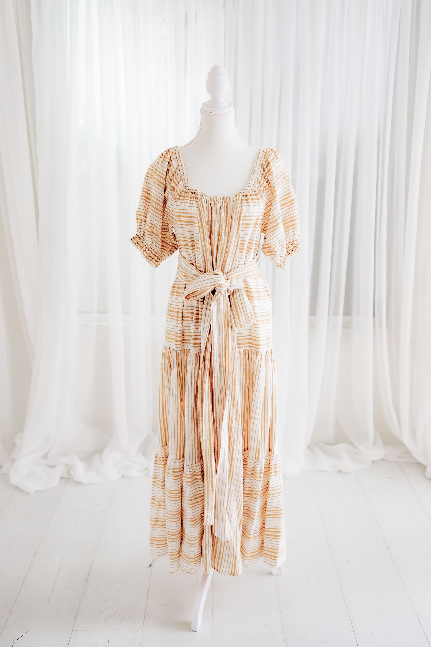 Full-length view of striped cotton maxi dress with puff sleeves and waist tie.