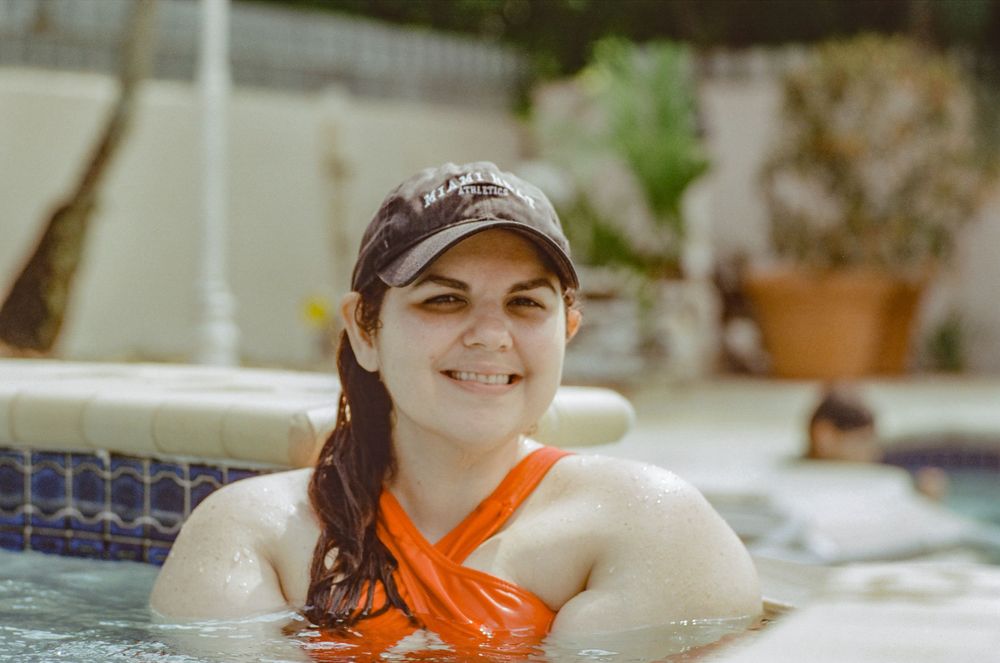 Person wearing an orange scarf relaxing in a swimming pool.