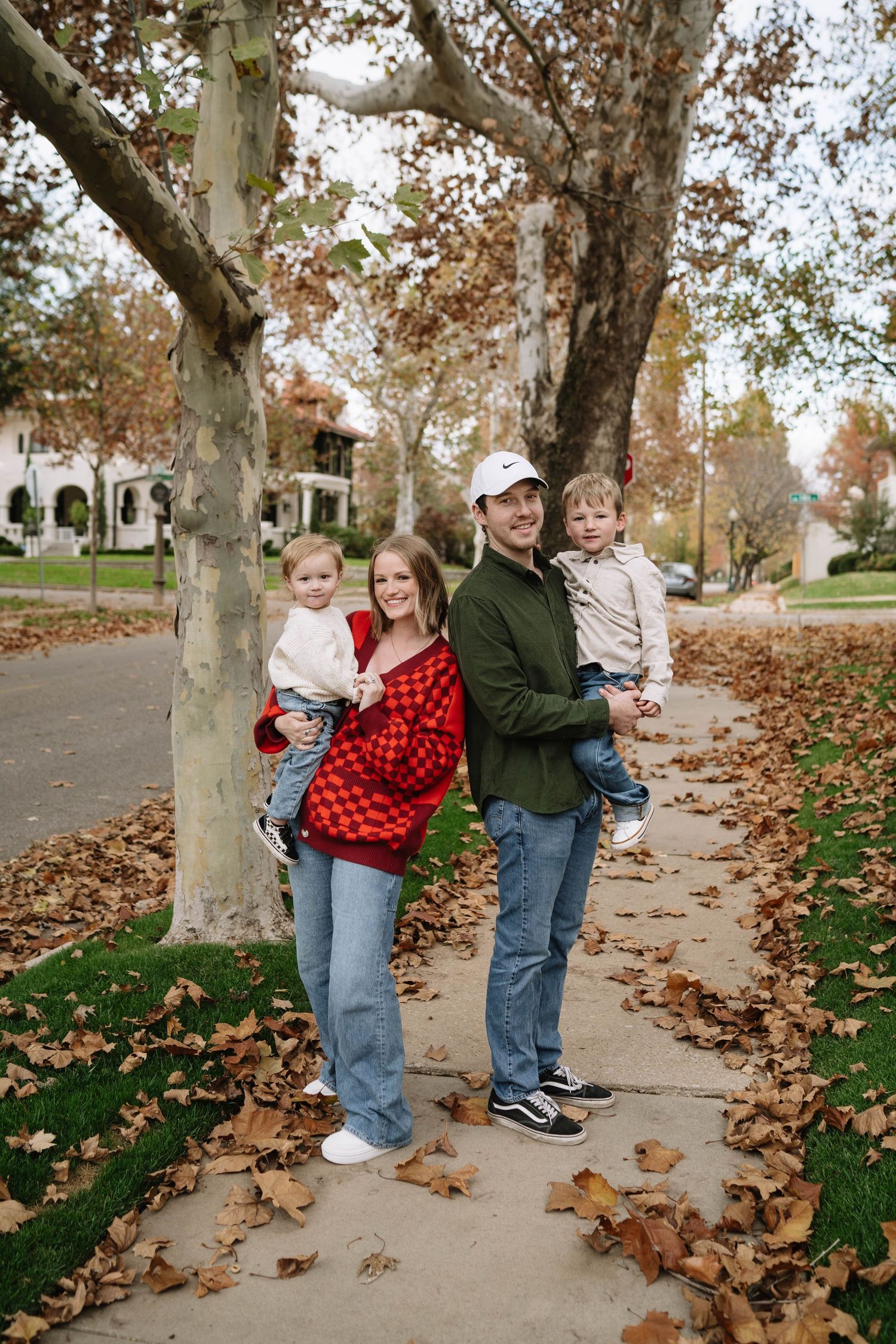 Family poses together in garden setting with colorful flowers and blooming landscape.