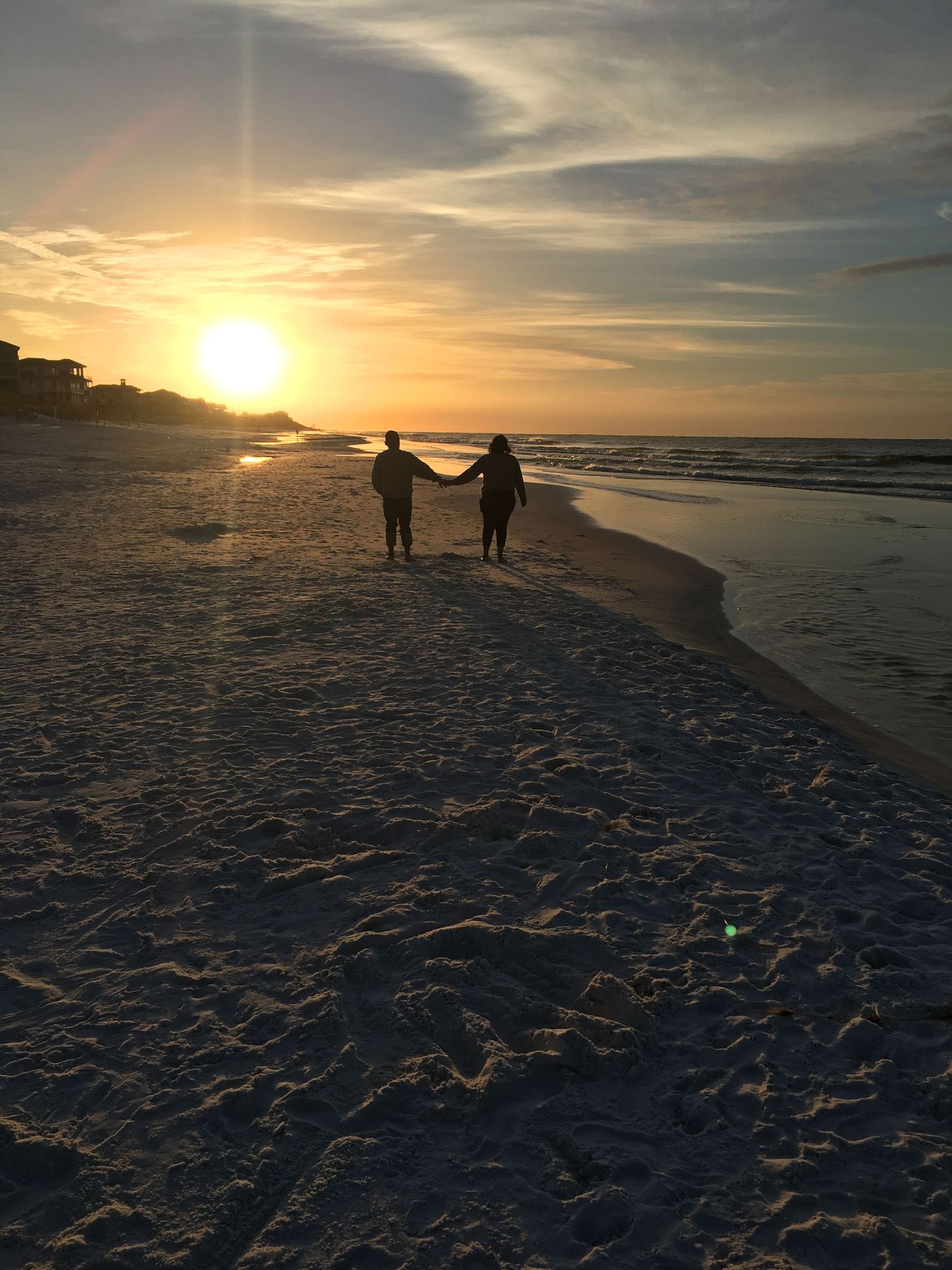 couple walking along the beach at sunrise