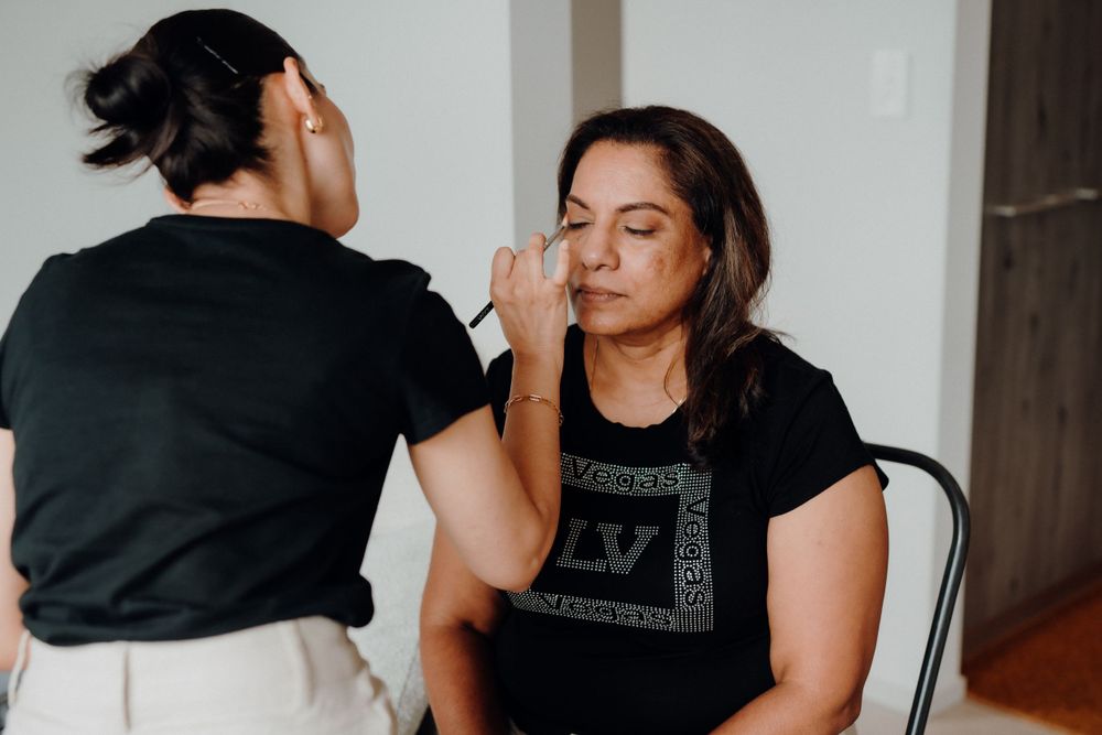 A makeup artist applying cosmetics during a wedding preparation session.
