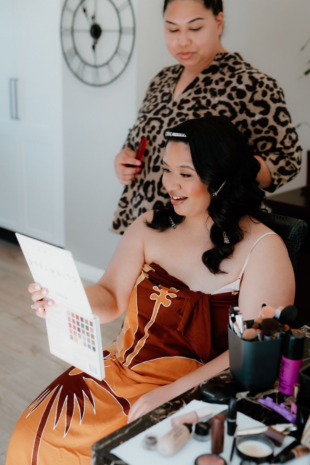 Wedding preparation scene with someone in a leopard print robe doing makeup.