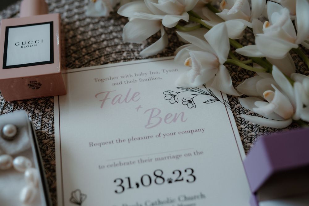 Wedding invitation with floral details and the date 31.08.23 surrounded by white flowers.